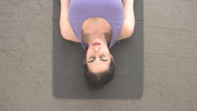 overhead shot woman laying on yoga mat